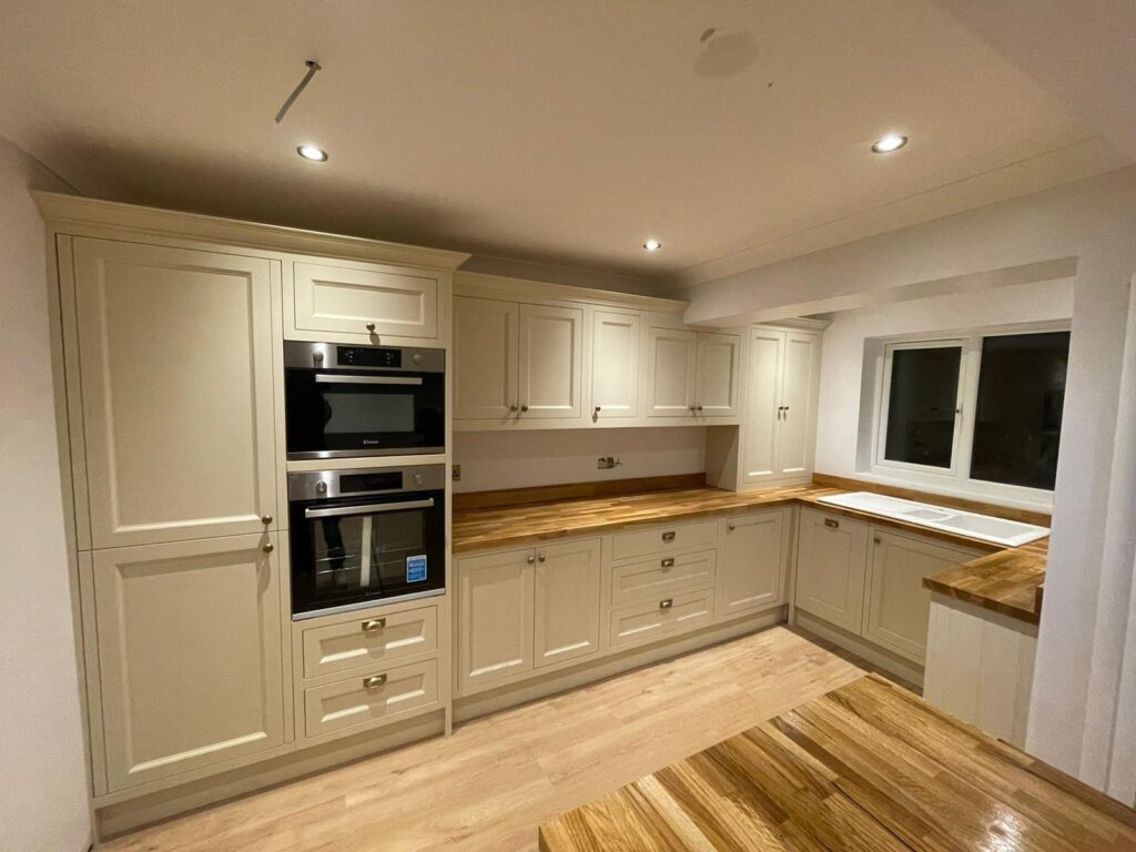 Elegant bespoke kitchen featuring cream cabinetry, marble countertops, and integrated appliances, designed and installed by Tulip Kitchens.