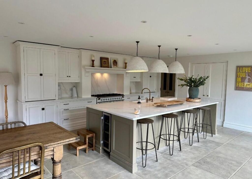 Bespoke kitchen design in Nottinghamshire featuring a large central island with marble worktop, handcrafted cabinetry, pendant lighting, and integrated storage — created by Tulip Kitchens.
